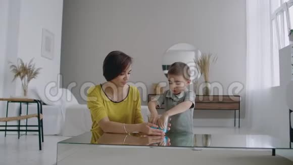 开心地笑着妈妈和儿子一起玩一个液体可伸缩的玩具视频的预览图