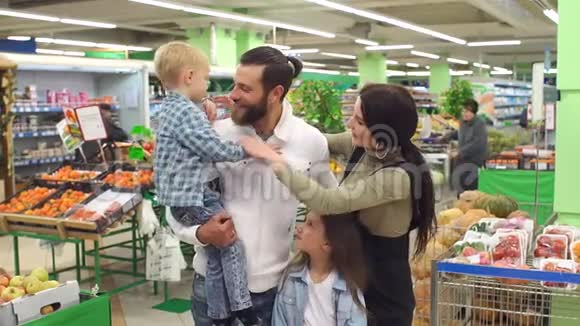 一个幸福的大家庭在超市里小儿子拥抱他的父亲的画像视频的预览图