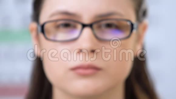 女性戴着半闭眼的眼镜视力有问题视频的预览图