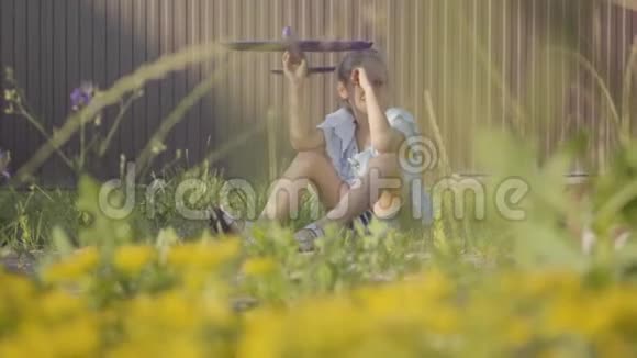 可爱的女孩带着玩具飞机坐在院子里的绿草上在户外玩的女孩免费儿童视频的预览图