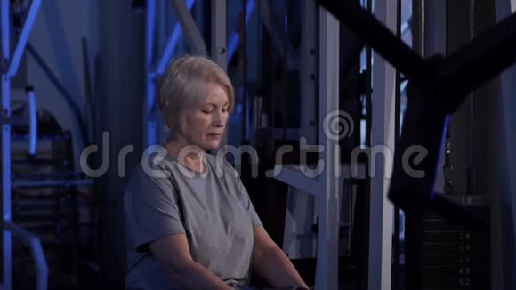 膝对胸部交替上升的坐姿一位年长的女子练习关节体操复制空间视频的预览图
