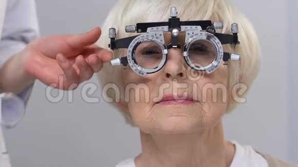 光学师将镜片放入phopter中佩戴高级女性病人医疗保健视频的预览图