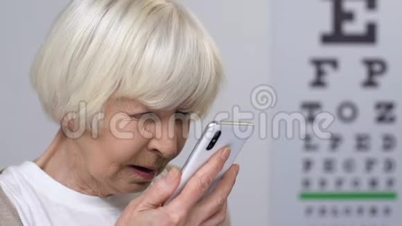 有视力问题的老年女性在智能手机上阅读信息视频的预览图