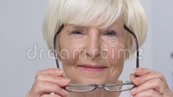 戴眼镜的老年妇女微笑光学商店的老年顾客视频的预览图