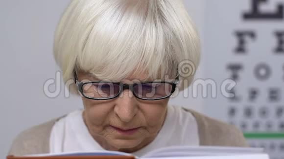 戴眼镜的悲伤老年妇女看书视力问题失明视频的预览图