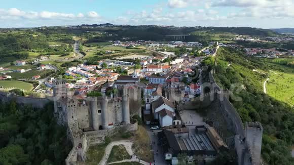日落时分在葡萄牙里斯本附近鸟瞰历史城墙的奥比多斯镇葡萄牙奥比多斯中世纪小镇的空中拍摄视频的预览图