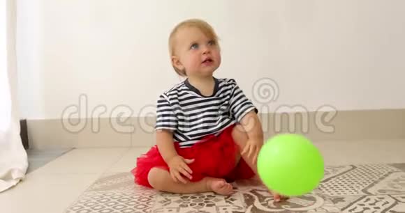 可爱的宝宝坐在地板上围着五颜六色的气球视频的预览图