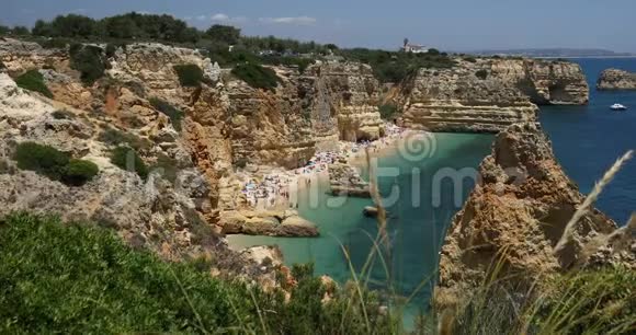 天然洞穴在马林哈海滩阿尔加维葡萄牙Marinha海滩的岩石悬崖拱门和葡萄牙海岸的绿松石海水视频的预览图