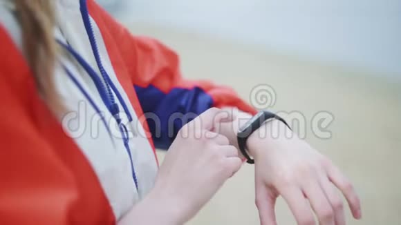 女人在跑步后检查智能手表或健身手镯上的脉搏视频的预览图