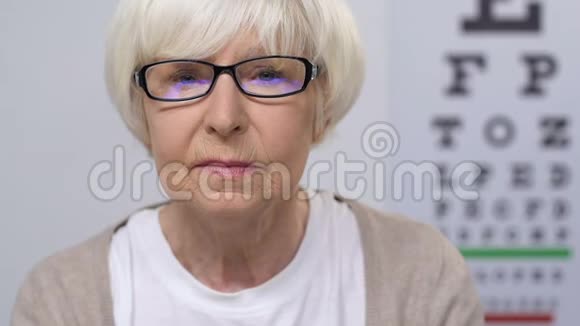 令戴眼镜的老年妇女不安的是看报纸视力问题疾病视频的预览图