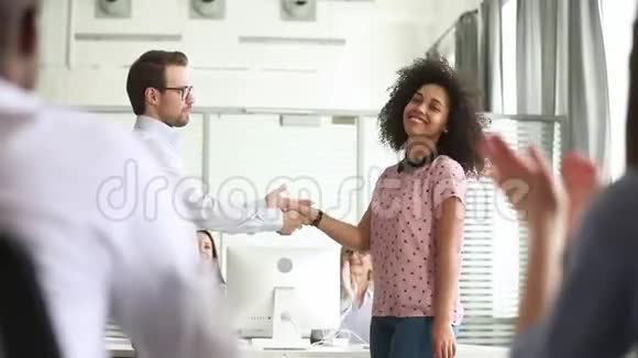 骄傲的高加索男经理握手赞美快乐的非洲女员工视频的预览图