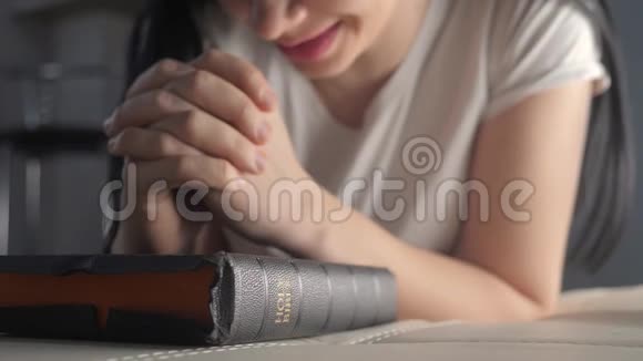 女孩在睡前在室内祈祷生活方式圣经宗教观念晚祷妇女深色手圣经视频的预览图