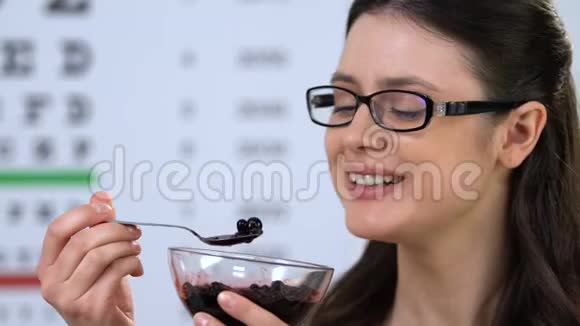 快乐的女性戴眼镜吃越橘维生素健康视力视频的预览图