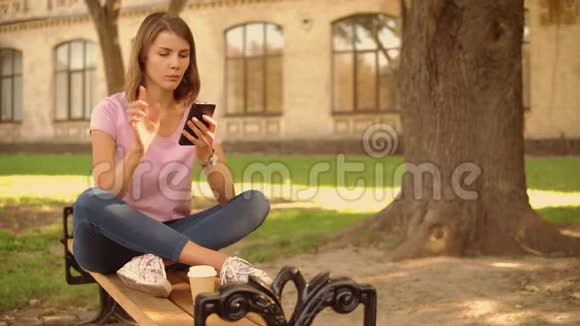 年轻女子在大学附近使用智能手机视频的预览图