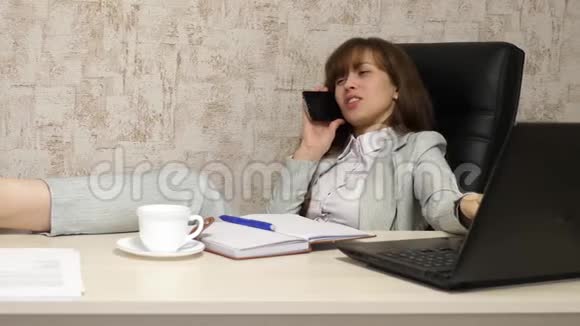 在办公室工作的女孩正在谈判智能手机手里拿着一杯咖啡电脑工作漂亮的商业女人视频的预览图