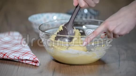 做甜点一个女人在装有面团的容器中加入黑巧克力片是个搅拌器视频的预览图