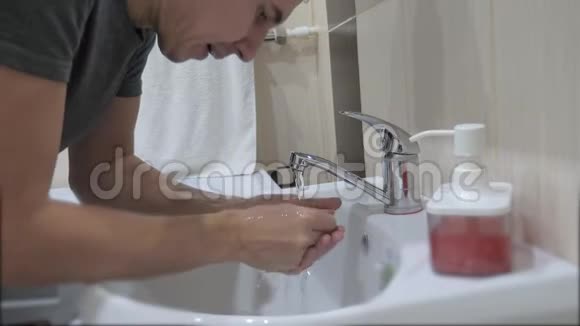 男人用自来水在浴室里洗手男人吃饭前洗了手卫生运动视频的预览图