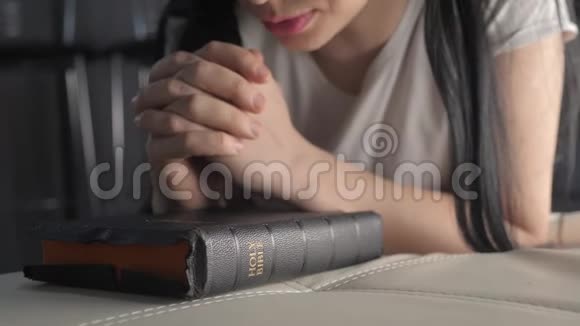 女孩祈祷室内生活方式在睡前圣经宗教观念晚祷妇女深色手圣经视频的预览图