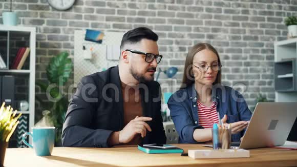 无止境的循环男人和女人用笔记本电脑工作而咖啡杯热气腾腾视频的预览图