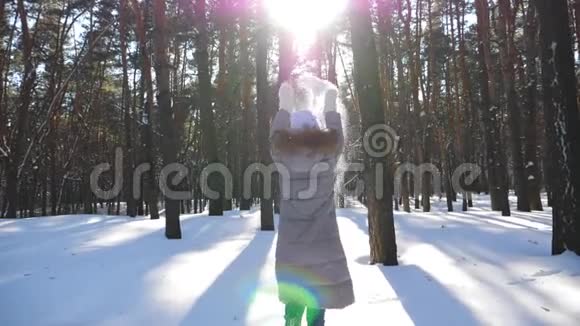 面目全非的女人在雪林中奔跑扔着一把雪快乐的女孩享受美丽的冬天视频的预览图