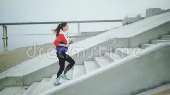 年轻活泼的女人在城市楼梯上跑上楼视频的预览图