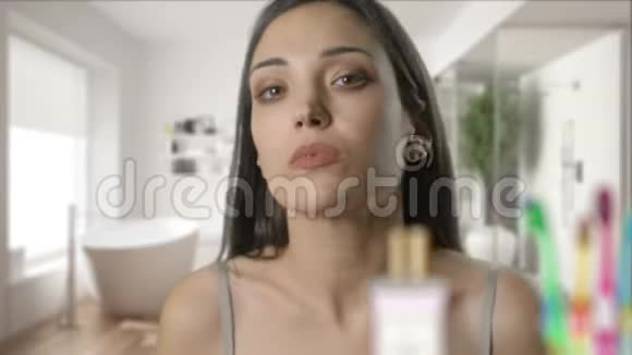年轻女子正在家里的浴室镜子里检查她的脸漂亮的女孩正在看镜子摸她的皮肤视频的预览图