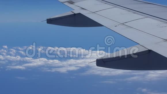 从机翼和云层上的飞机窗口观看去其他国家旅行视频的预览图