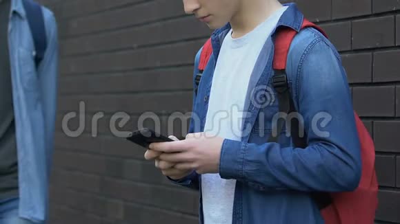 粗鲁的黑人少年抓着高加索男孩的智能手机试图表现出不尊重视频的预览图