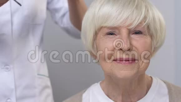 医生给有视力问题的老年幸福妇女戴眼镜健康视频的预览图