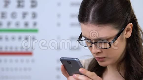 戴眼镜的微笑女人通过智能手机与医生预约视频的预览图
