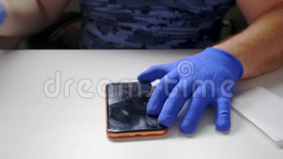 一只男性的手替换了一个破碎的钢化玻璃屏幕保护器用于智能手机视频的预览图