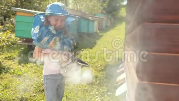 穿着养蜂专用衣服的小女孩抱着烟鬼让蜜蜂安静下来视频的预览图