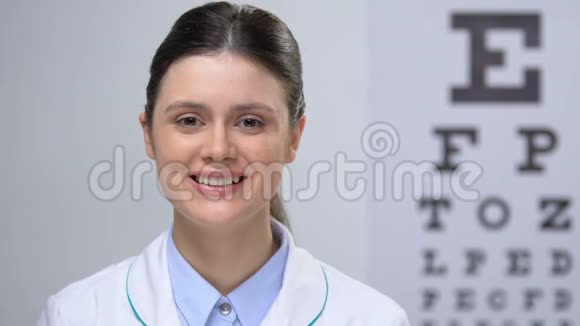 微笑女性眼科医生站在眼图背景下服务视频的预览图