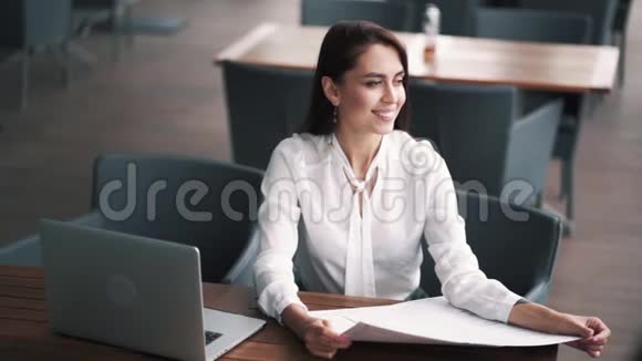 午餐时间女商人在咖啡馆里看着笔记本电脑在桌子上慢动作视频的预览图