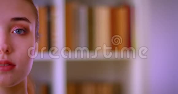 室内图书馆里年轻漂亮女生看镜头的特写半脸照视频的预览图