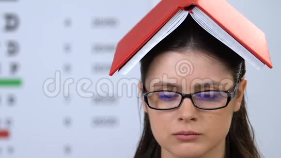 戴眼镜头戴书本探索信息学习的年轻女子视频的预览图
