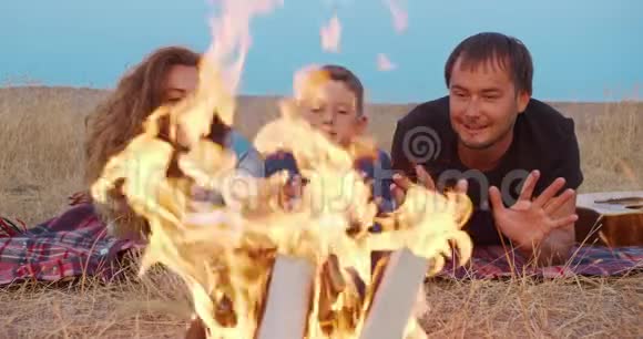 一家人晚上坐在户外篝火旁视频的预览图
