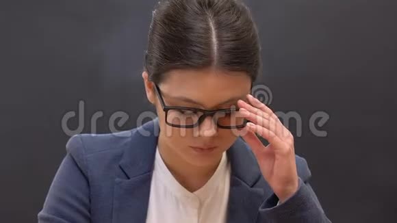 疲劳的女教师摘下眼镜按摩鼻子过度工作视频的预览图