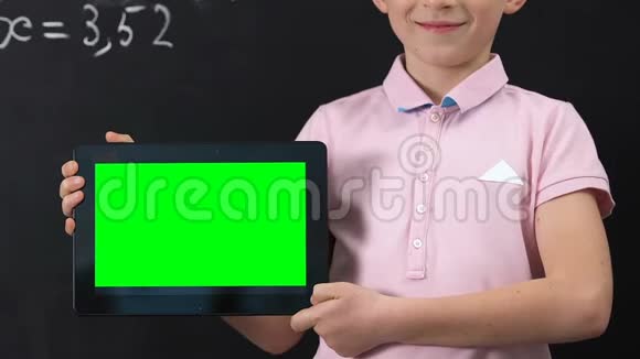 微笑小学生手持平板电脑绿色屏幕在线教育理念视频的预览图