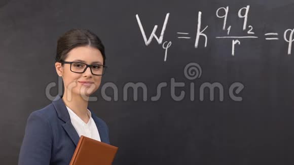 微笑老师看着相机物理公式写在黑板上视频的预览图