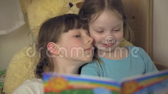 两个女孩正躺在孩子们的床上看书视频的预览图