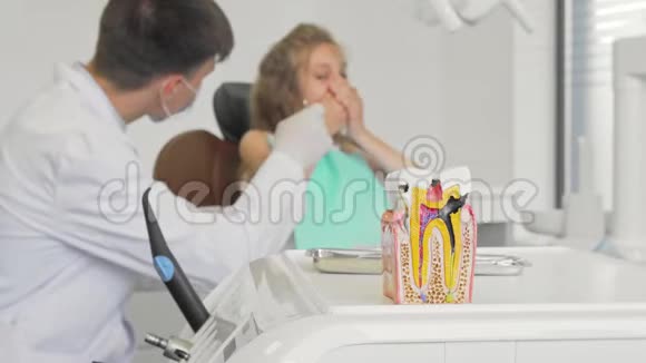 前景牙科医生与儿童合作的不健康牙齿模型视频的预览图