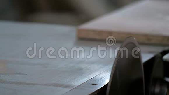 带有圆锯的机器从刨花板上锯下零件家具制造工人手推锯子的特写镜头视频的预览图