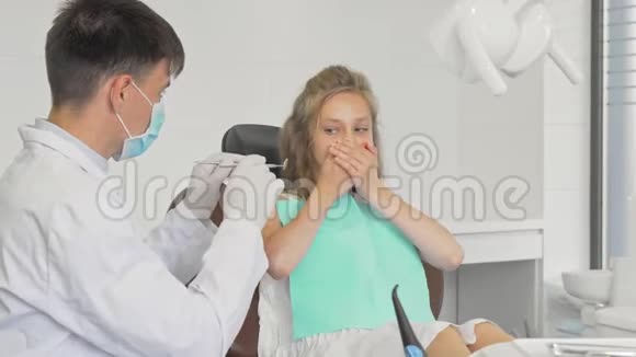 年轻女孩拒绝向牙医露牙用手捂住嘴视频的预览图