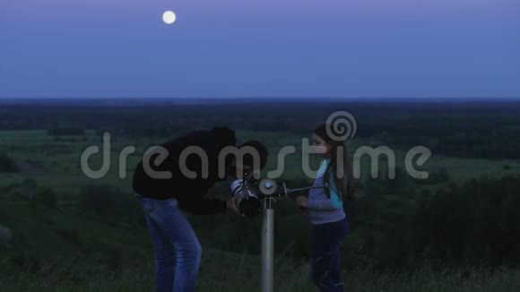 父亲和女儿用望远镜看月亮视频的预览图