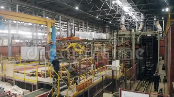 工人们正沿着工业大厅散步视频的预览图