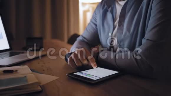 男人在桌上的数字平板电脑上浏览视频的预览图