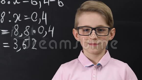 戴眼镜的小学生看着照相机黑板上写着数学方程式视频的预览图