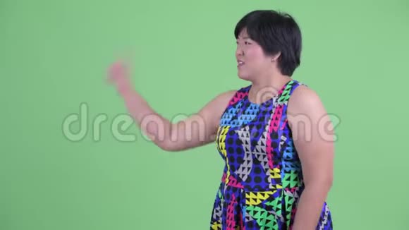 快乐的年轻超重的亚洲女人摸东西跳舞视频的预览图