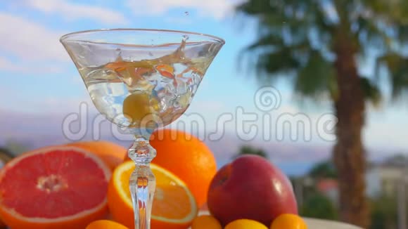 橄榄在柑橘类水果旁边倒入马提尼视频的预览图